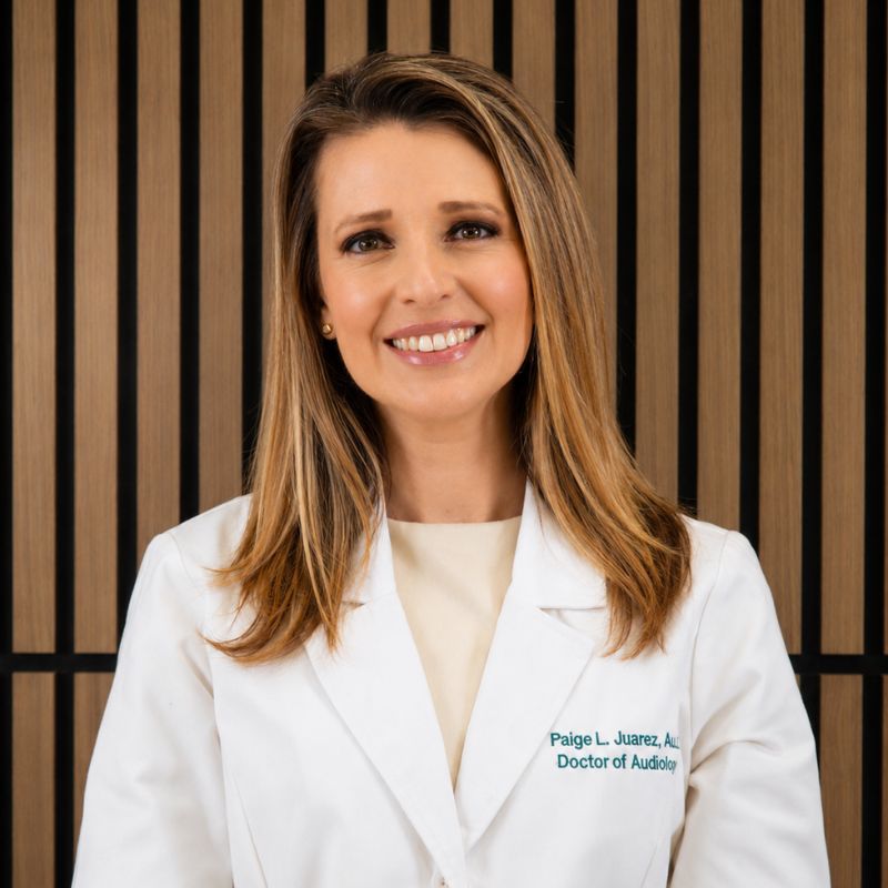 Dr. Paige Juarez, audiologist, smiling warmly in her white clinic coat